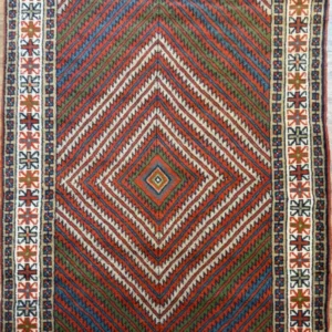 Hand-knotted Persian Afshar wool area rug 3.9' x 6.4' featuring concentric chevron diamond pattern in terracotta, sage green, and blue with an ivory border.