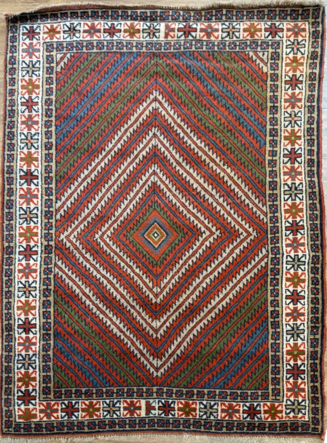 082426-3.webp | McFarlands Carpet and Rug Service Hand-knotted Persian Afshar wool area rug 3.9' x 6.4' featuring concentric chevron diamond pattern in terracotta, sage green, and blue with an ivory border.