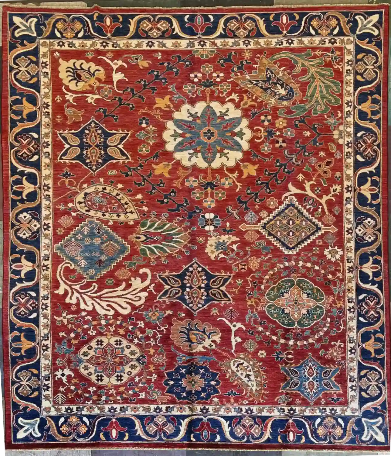 hand-knotted-chobi-wool-area-rug-8-3-x-10-rust-red-royal-blue-sku-112525-10.webp | McFarlands Carpet and Rug Service Rust red hand-knotted Chobi wool area rug 8.3' x 10' with scattered ivory medallions and a deep royal blue floral border.