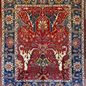 Ruby red hand-knotted Chobi wool area rug 7.11' x 10.2' with a mirror-image Tree of Life layout and a thick Prussian blue border.