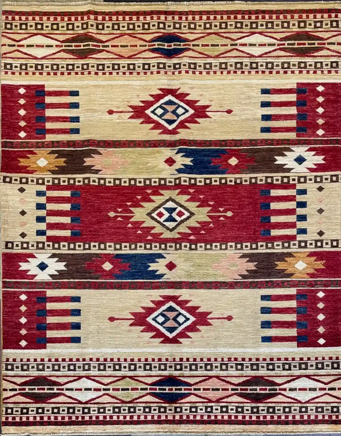 navajo-design-chobi-wool-rug-5x7.webp | McFarlands Carpet and Rug Service Terracotta red and cream hand-knotted Navajo design Chobi wool area rug 5.2' x 6.11' featuring large stepped geometric diamond medallions.