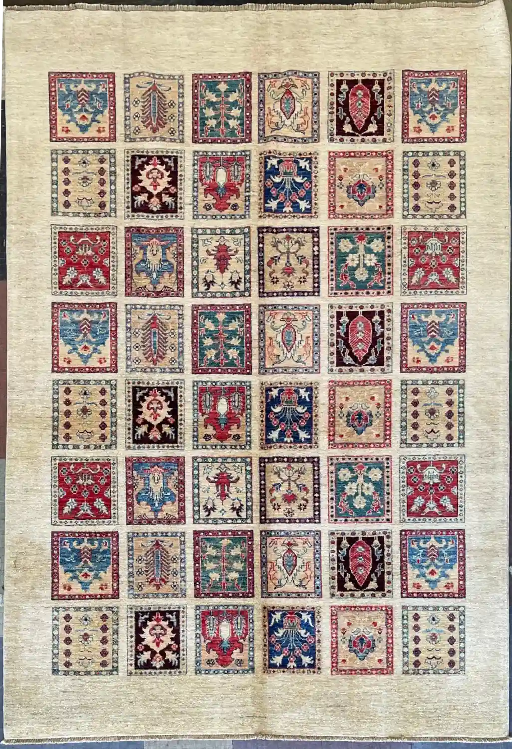 garden-panel-chobi-wool-rug-6x9.webp | McFarlands Carpet and Rug Service Decorative quilt panel with a grid of 7 by 8 colorful embroidered squares on a light background.