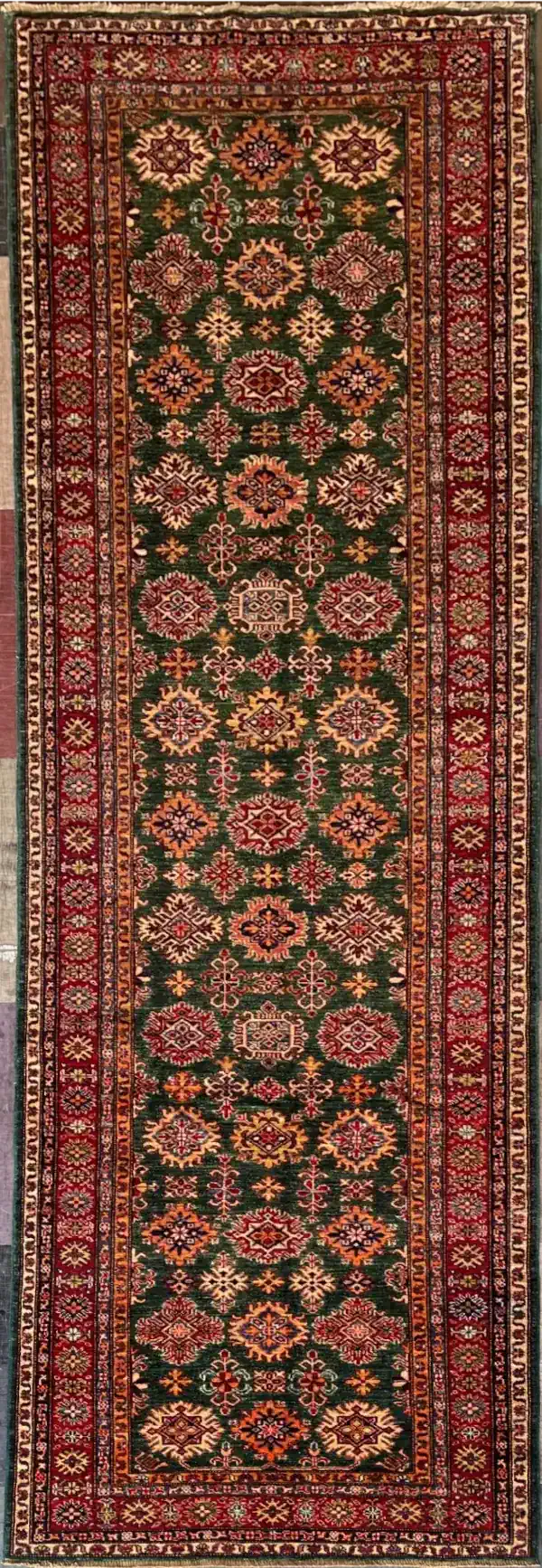 traditional-green-red-kazak-wool-runner-rug-4x12.webp | McFarlands Carpet and Rug Service Traditional green Kazak hand-knotted wool runner rug 4.1' x 12.6' featuring a dense geometric star medallion field and a wide crimson red border frame.