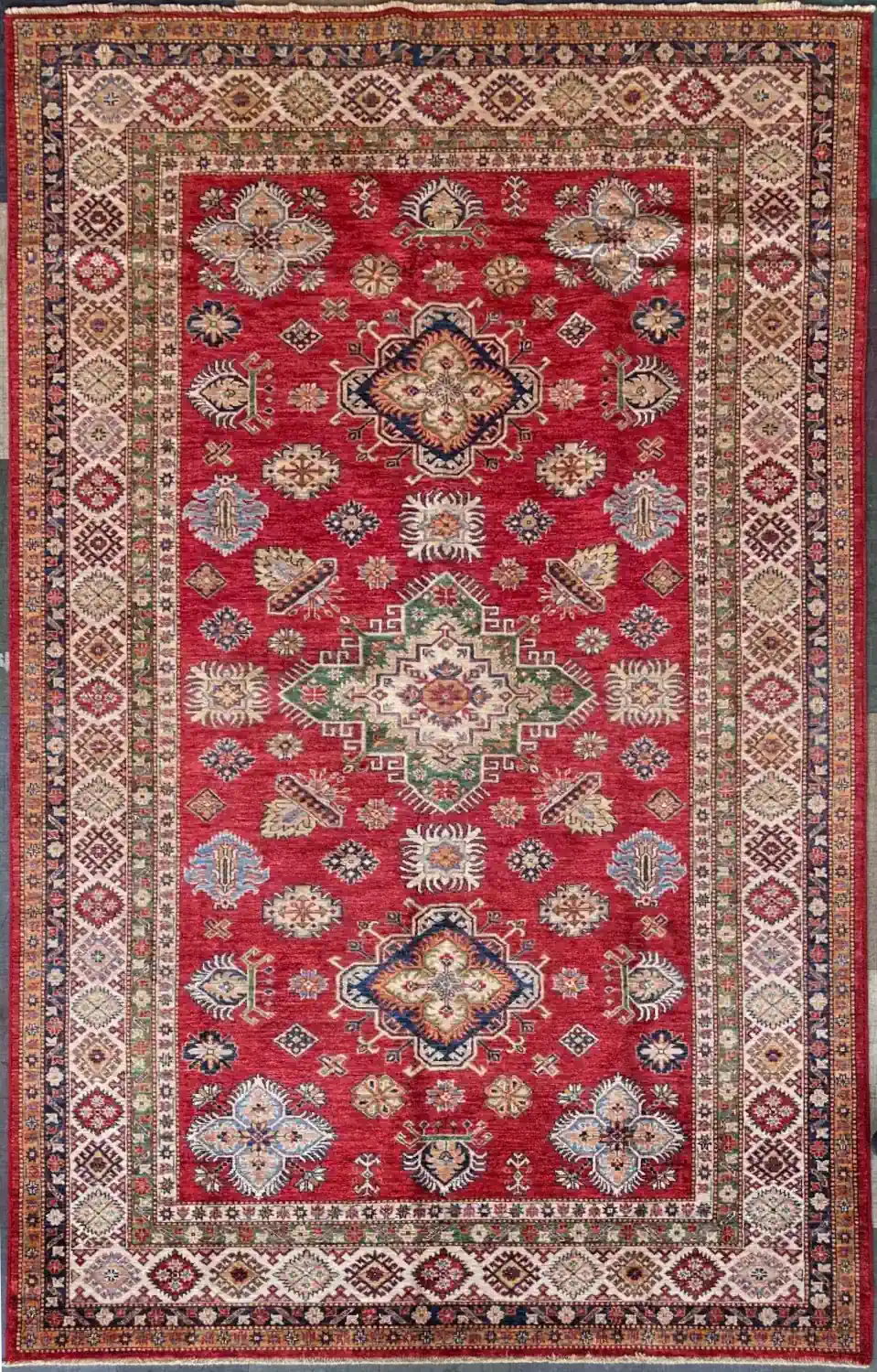 scarlet-sage-kazak-wool-accent-rug-5x10.webp | McFarlands Carpet and Rug Service Hand-knotted Kazak wool rug 5.7' x 10.7' featuring a scarlet red field, a central sage green stepped diamond medallion, and an ivory geometric border.