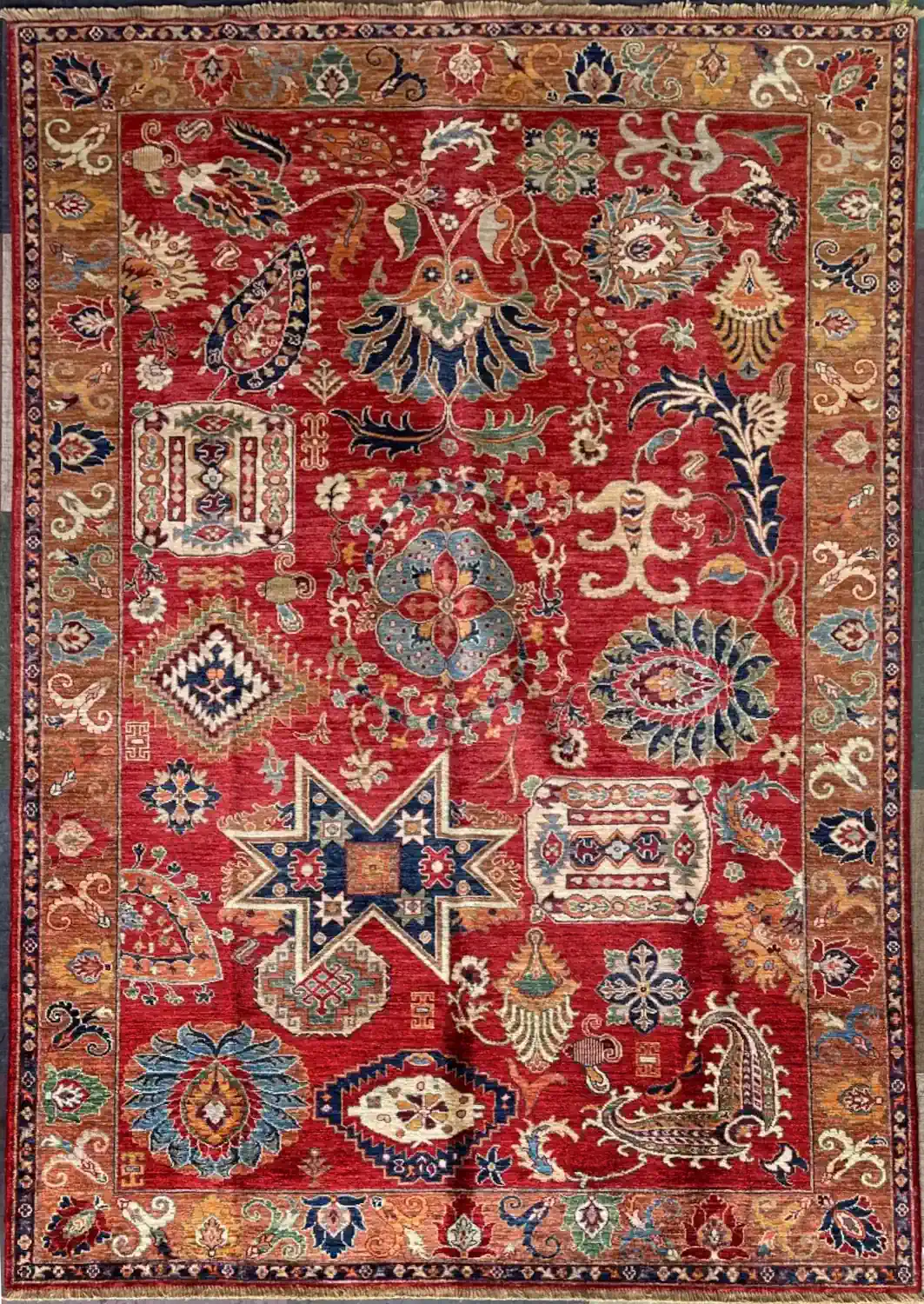 crimson-red-chobi-wool-sampler-area-rug-6x9.webp | McFarlands Carpet and Rug Service Hand-knotted Chobi wool area rug 6.2' x 9.1' with crimson red field, eclectic sampler motifs, and a tan floral border.