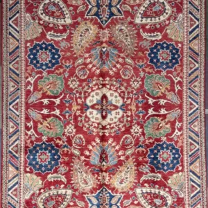 Hand-knotted Chobi wool area rug 6.2' x 9' with crimson red field, floral medallions, and a geometric chevron border.