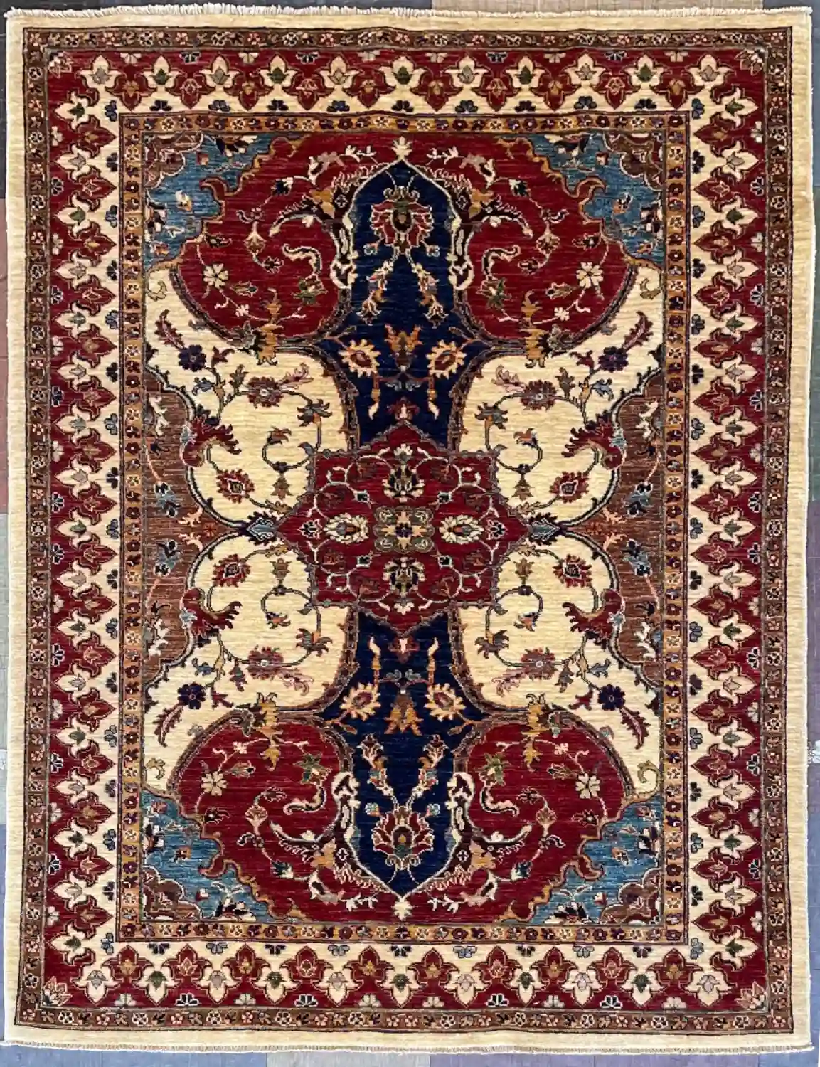red-navy-chobi-peshawar-wool-rug-5x7.webp | McFarlands Carpet and Rug Service Traditional red and navy Chobi Peshawar hand-knotted wool area rug 4.11' x 6.7' featuring an interlocking geometric floral field and an ivory border frame.