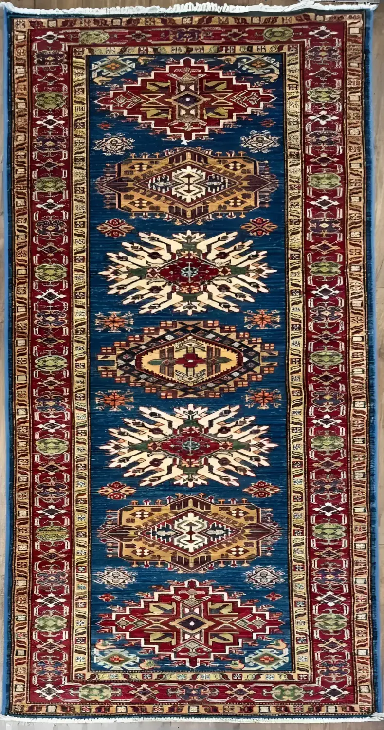 Con-12525-24.webp | McFarlands Carpet and Rug Service Hand-knotted Pakistan Kazak wool runner rug 2.9' x 8.5' featuring an indigo blue field with six geometric medallions in ruby red, gold, and ivory framed by a red tribal border.