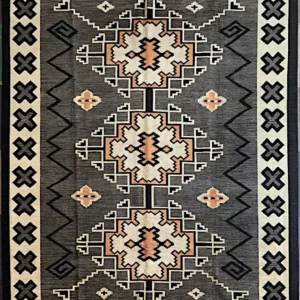 con12525-3 | McFarlands Carpet and Rug Service Decorative area rug with three large geometric medallions on a dark gray field and a border of X-shaped motifs.