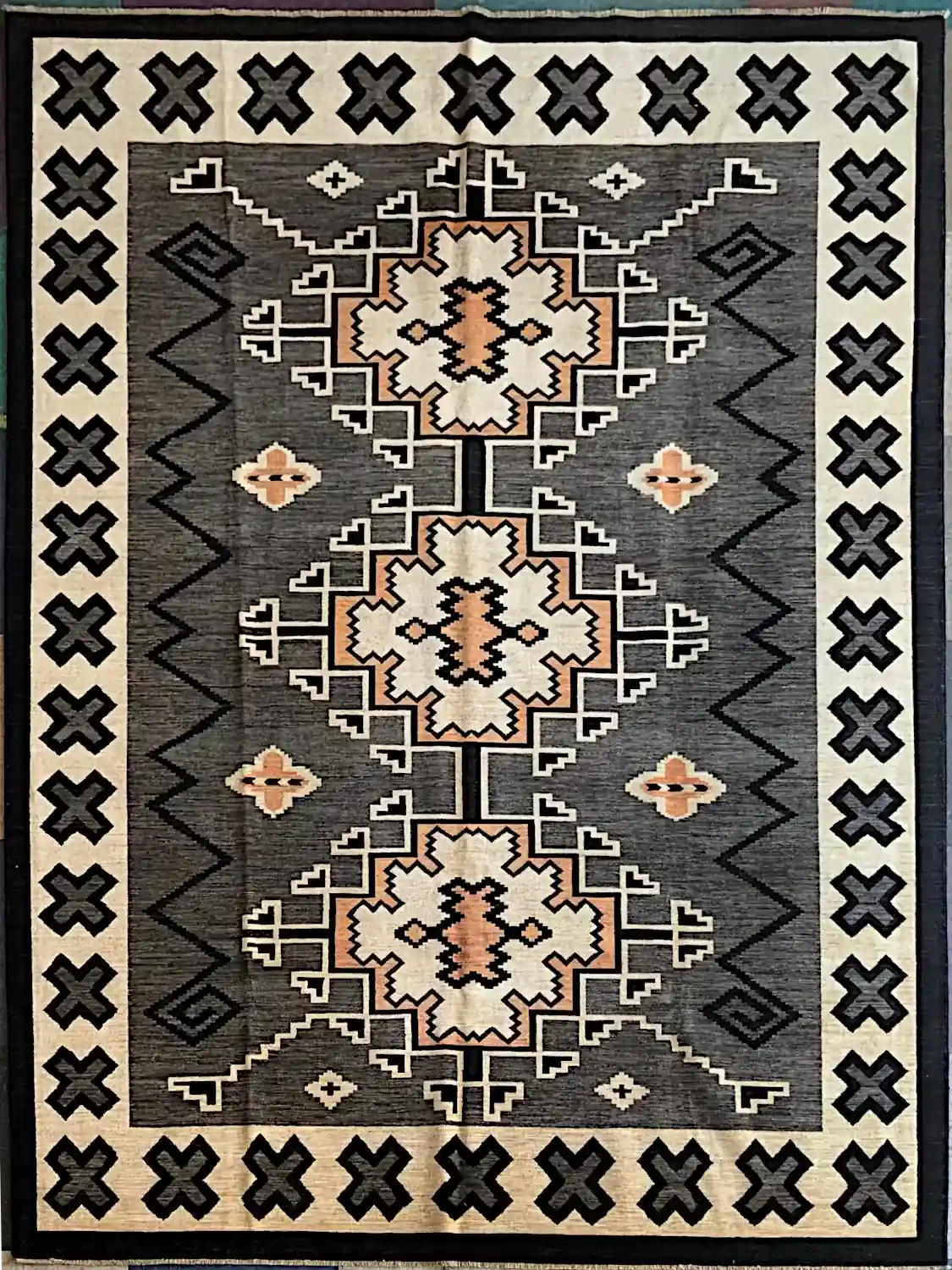 con12525-3 | McFarlands Carpet and Rug Service Decorative area rug with three large geometric medallions on a dark gray field and a border of X-shaped motifs.